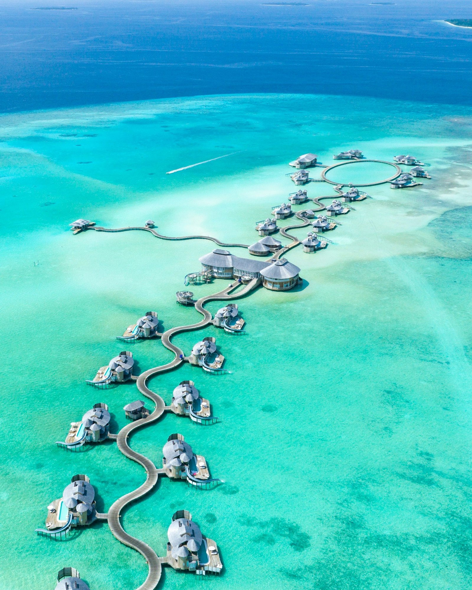 Overwater villas stretching over clear turquoise lagoon in the Maldives